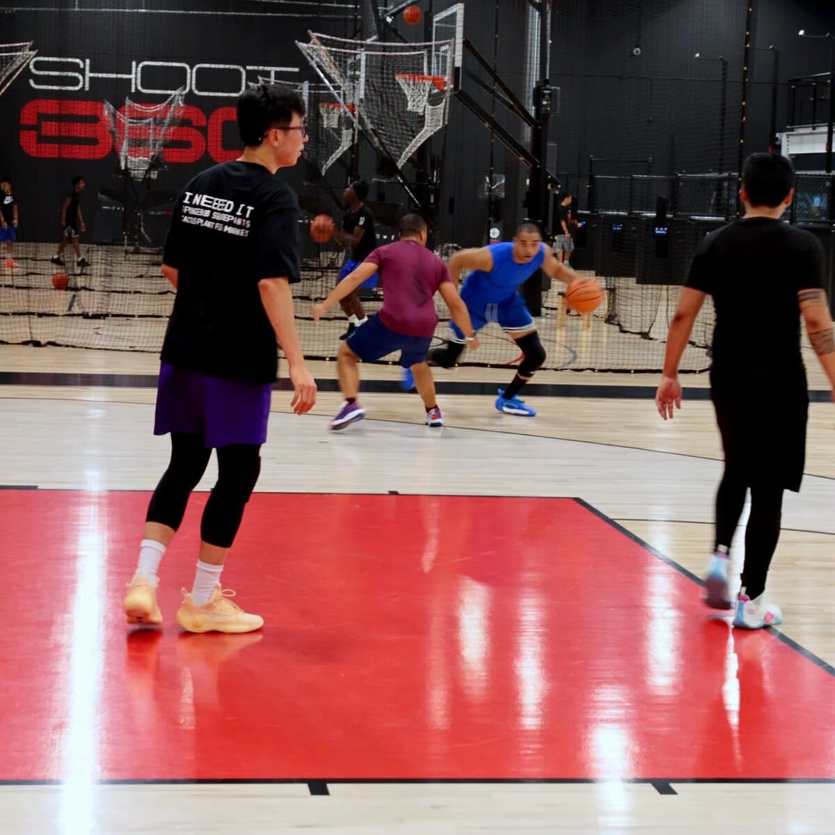 A player driving past a defender in front of the Shoot 360 sign in Calgary